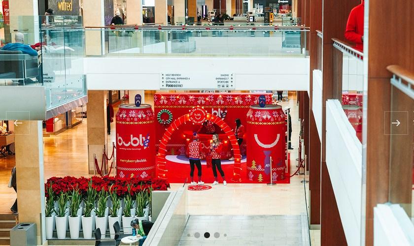 Red bubly-branded holiday photo activation in the mall with poinsettias