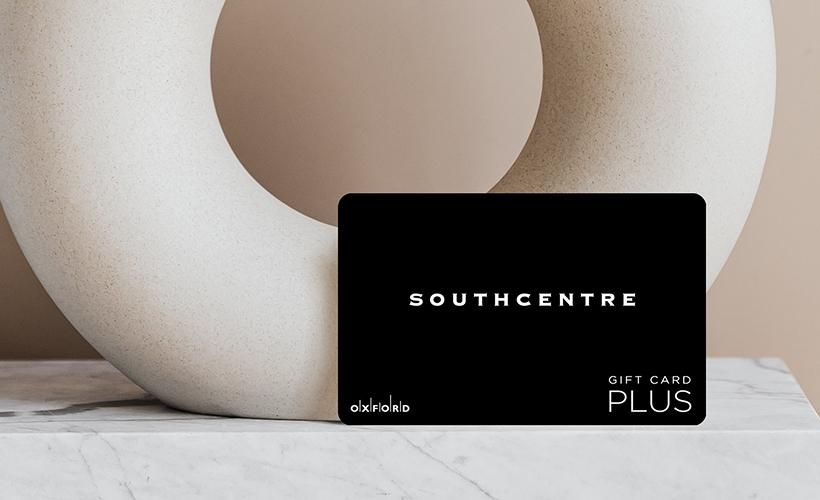 Black Southcentre Plus gift card beside a white sculptural ring on marble