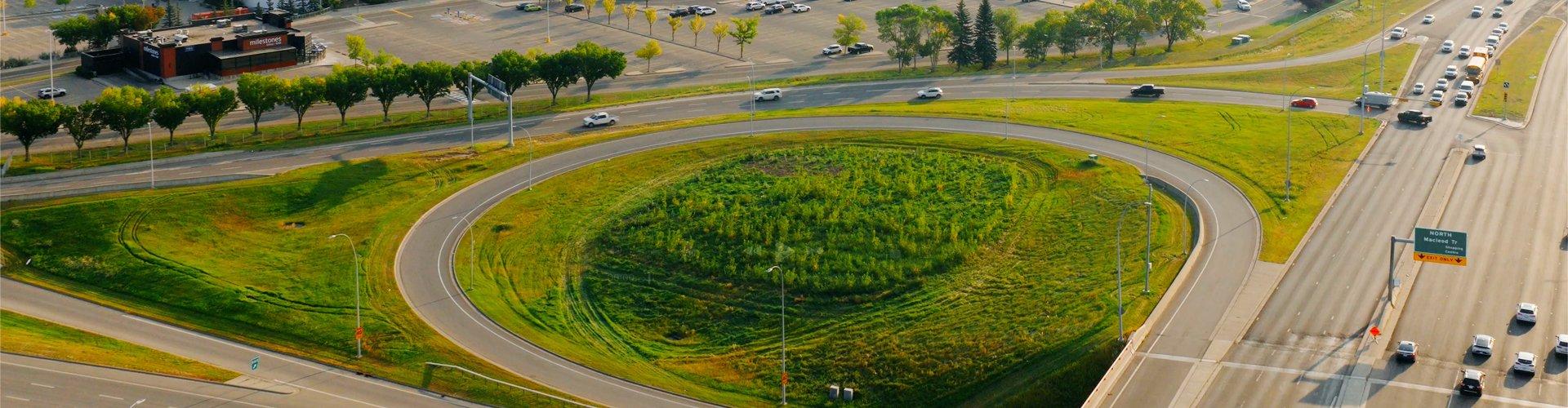 Aerial view of a landscaped highway interchange with a green loop