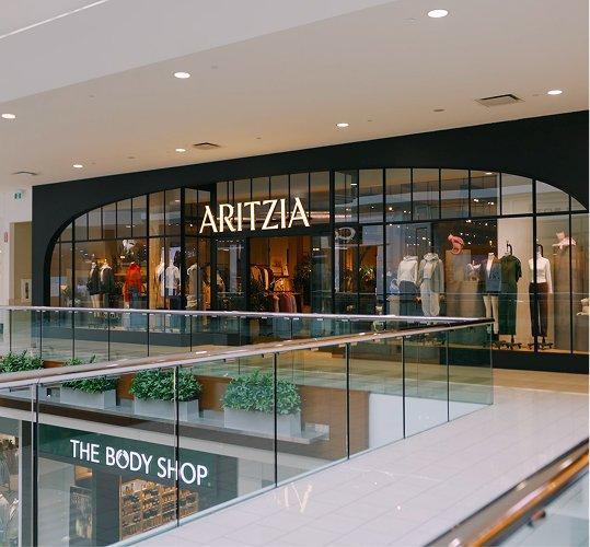Aritzia storefront above The Body Shop across a mall balcony
