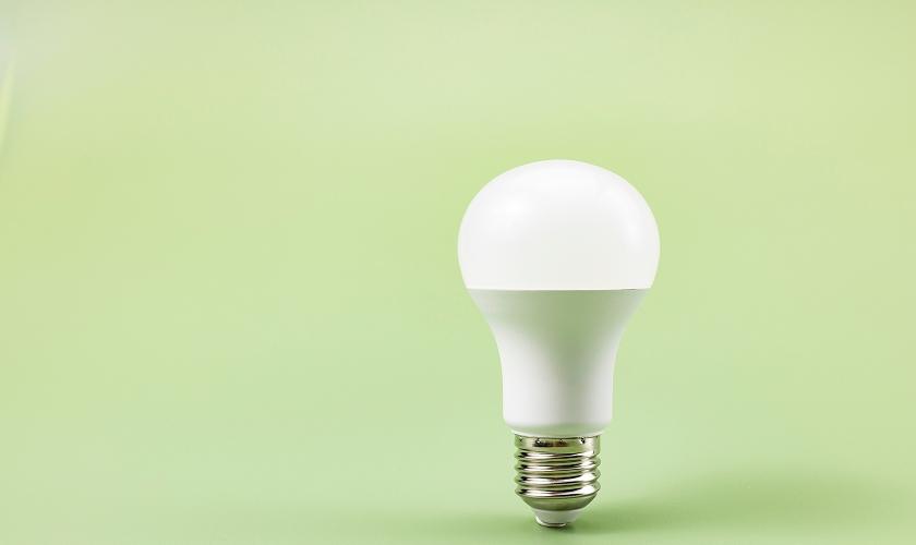 Single white LED light bulb on a soft green background