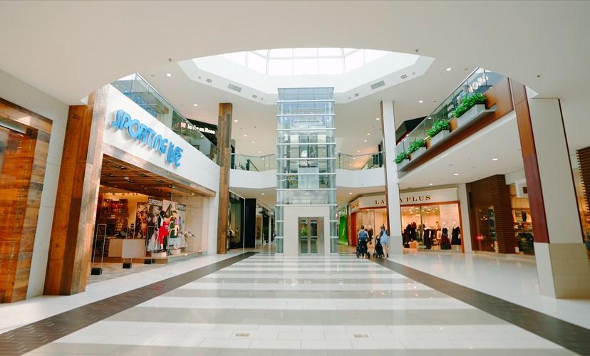 Two-level mall atrium with a glass elevator and Sporting Life store