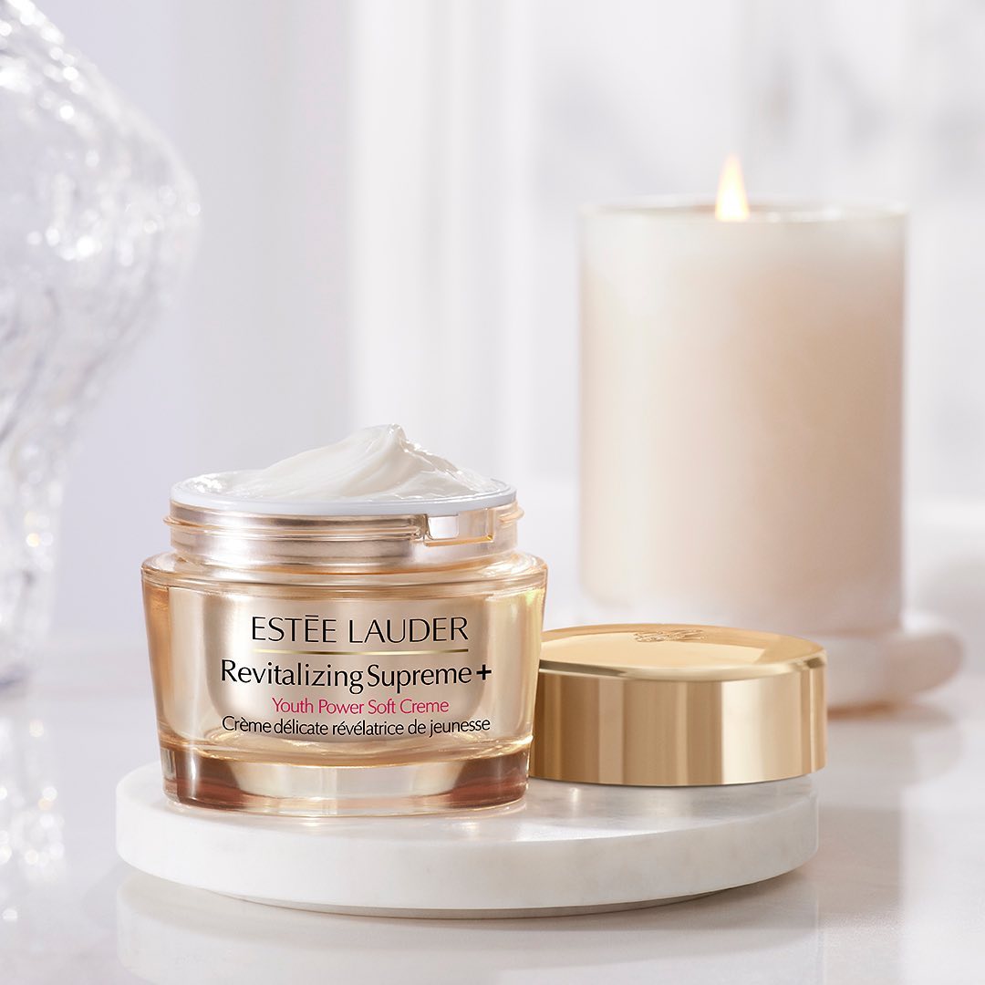 Estee Lauder creme sits on a counter alongside a white candle.