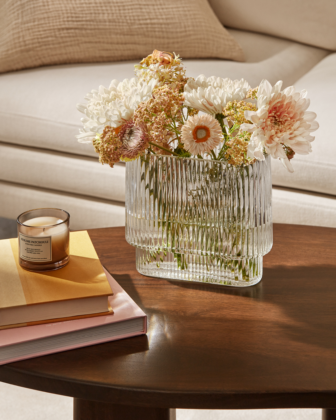 A ribbed glass vase is filled with flowers.