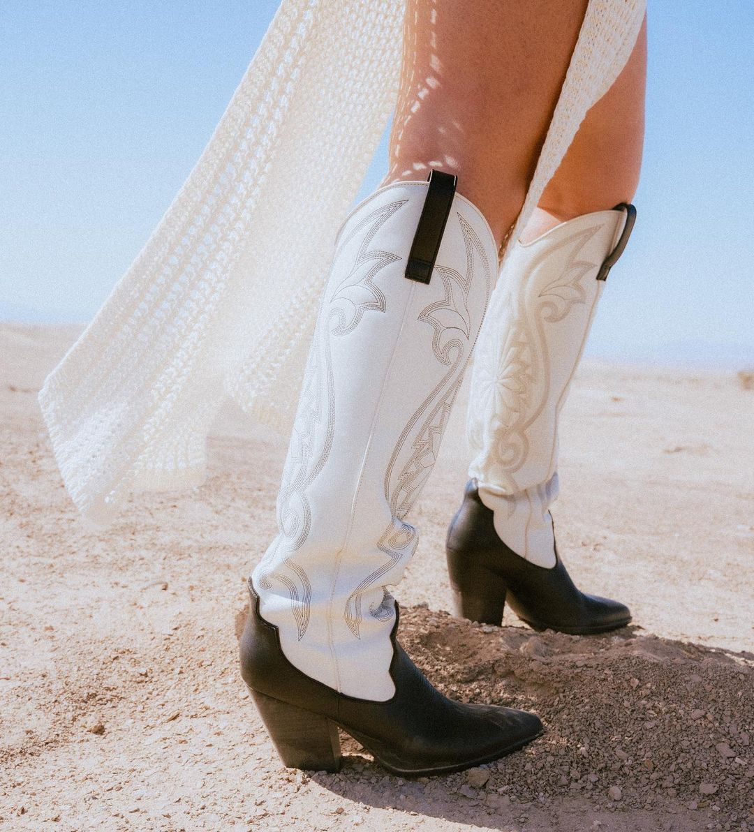 close-up image of a woman wearing tall black and white cowboy boots