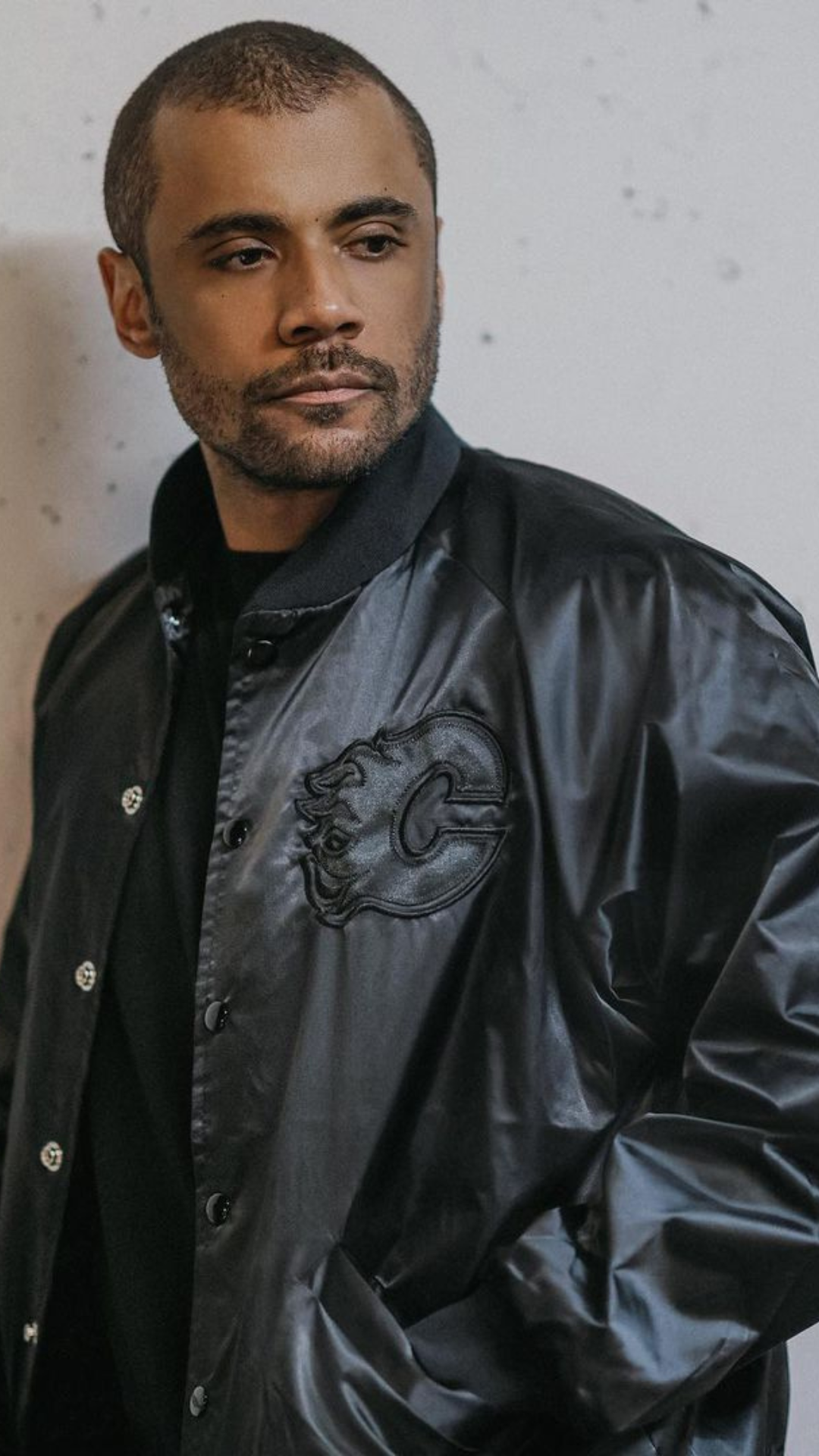 image of a man wearing a black bomber jacket iwth the calgary flames logo on the front