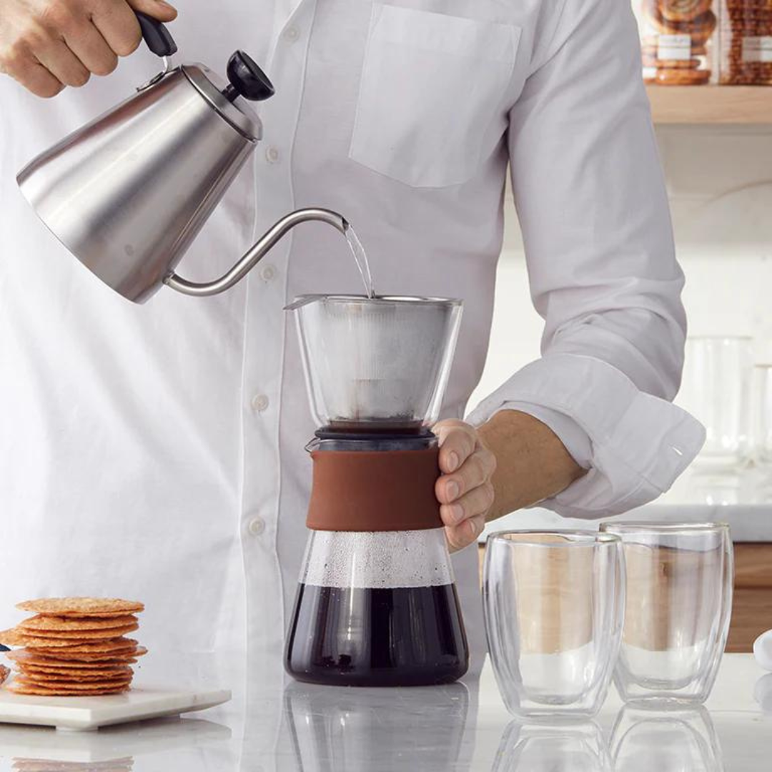 image of a man in a kitchen using a pourover coffee device
