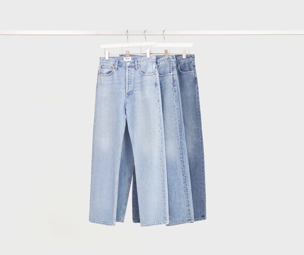 three pairs of jeans hanging on a hanger