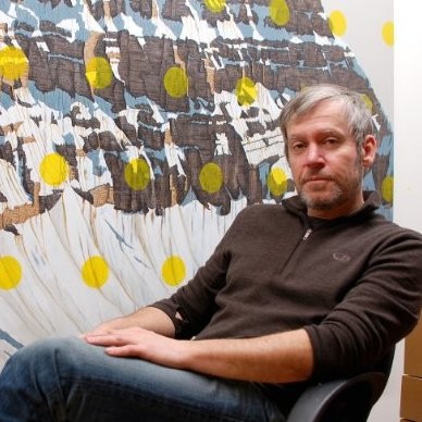 David Pirrie sitting in a chair in front of a painting