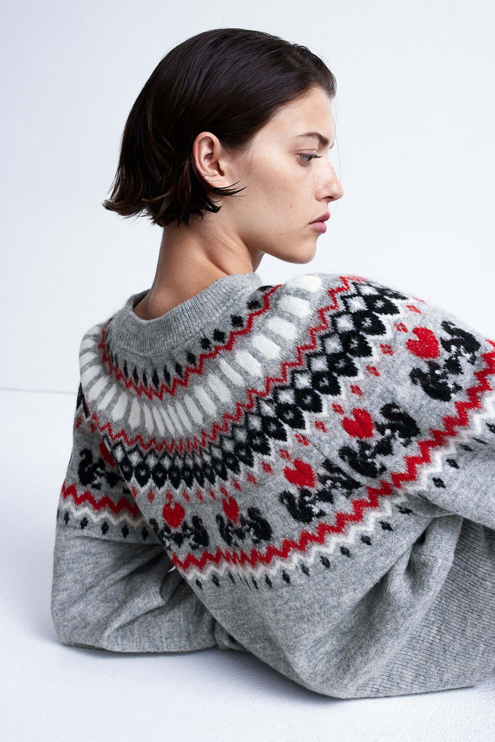 woman wearing knitted grey christmas sweater with raglan sleeves