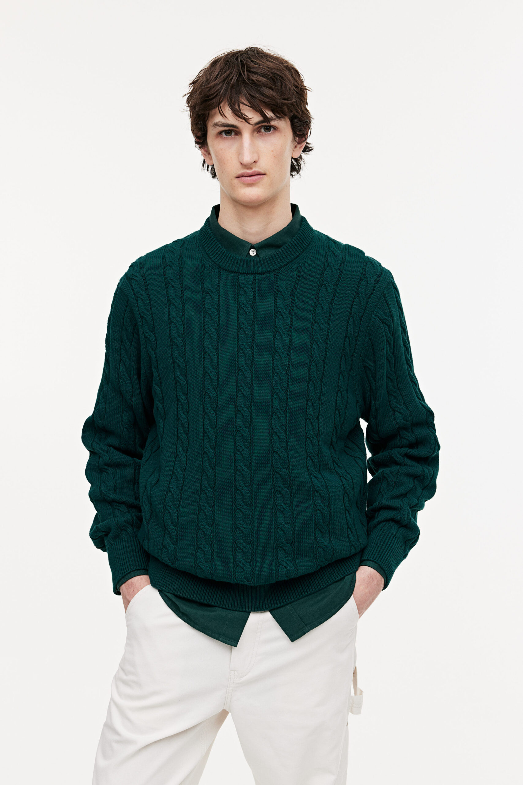 man in a green cable knit sweater