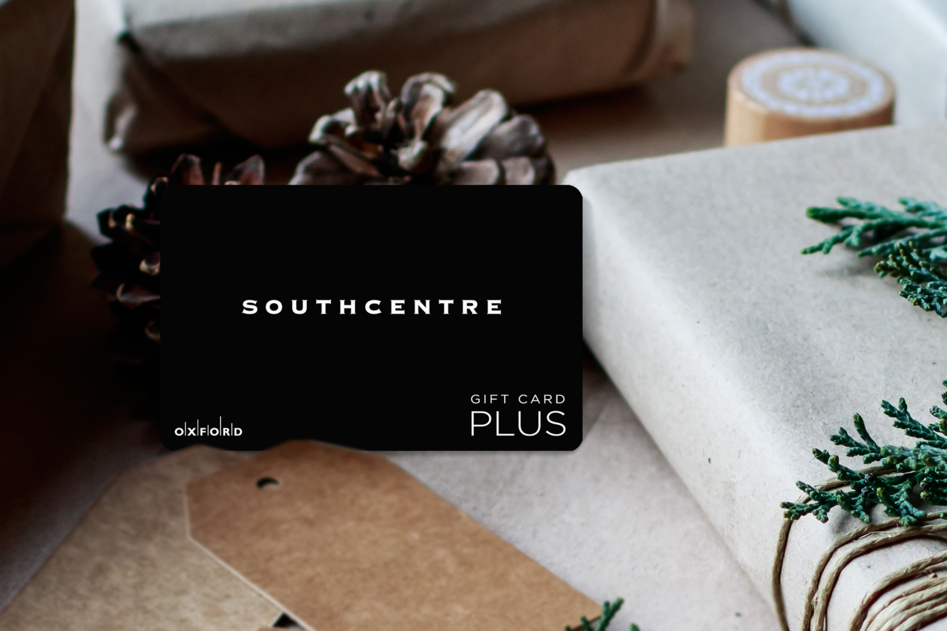 promotional image of a black southcentre gift card surrounded by gift-wrapped books in a holiday setting