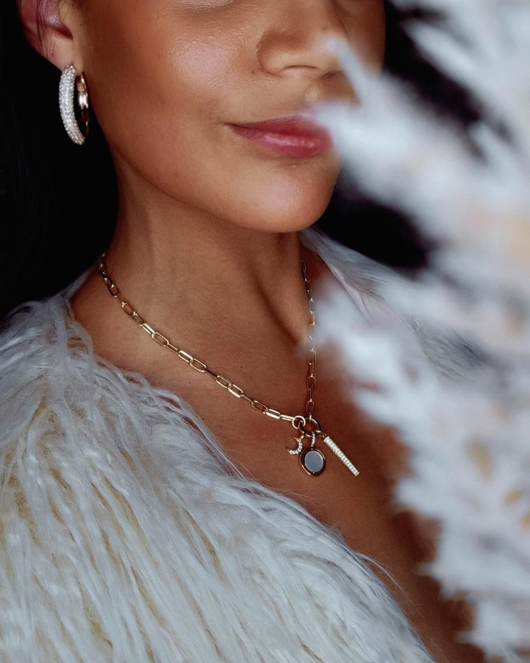 a person wearing a white fur coat and earrings
