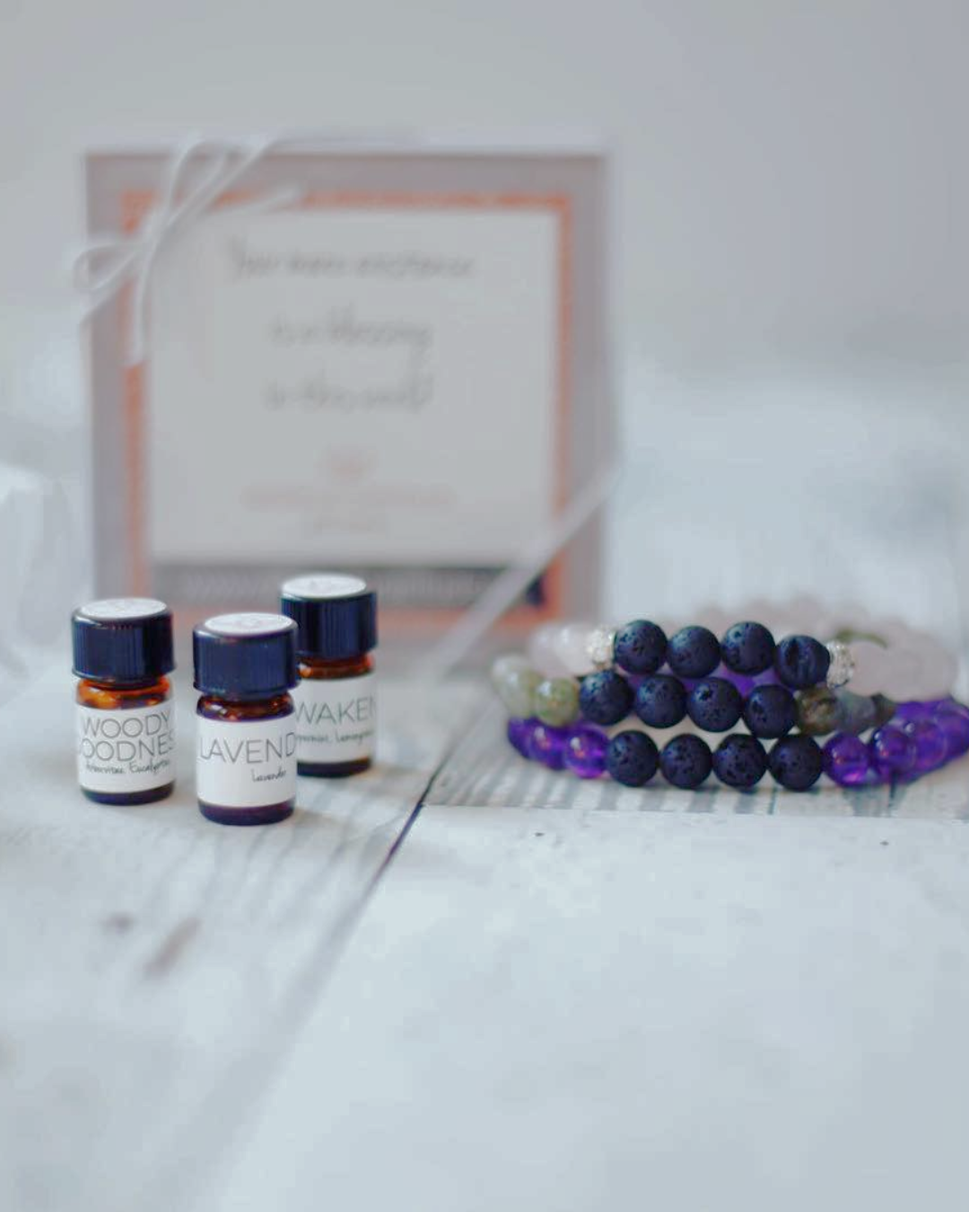 a group of bottles of essential oils and a bracelet