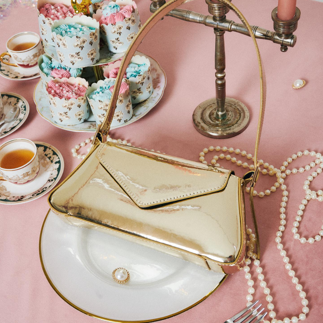 a gold clutch and pearl necklace