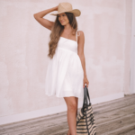 girl wearing white flowy dress and cowboy hat