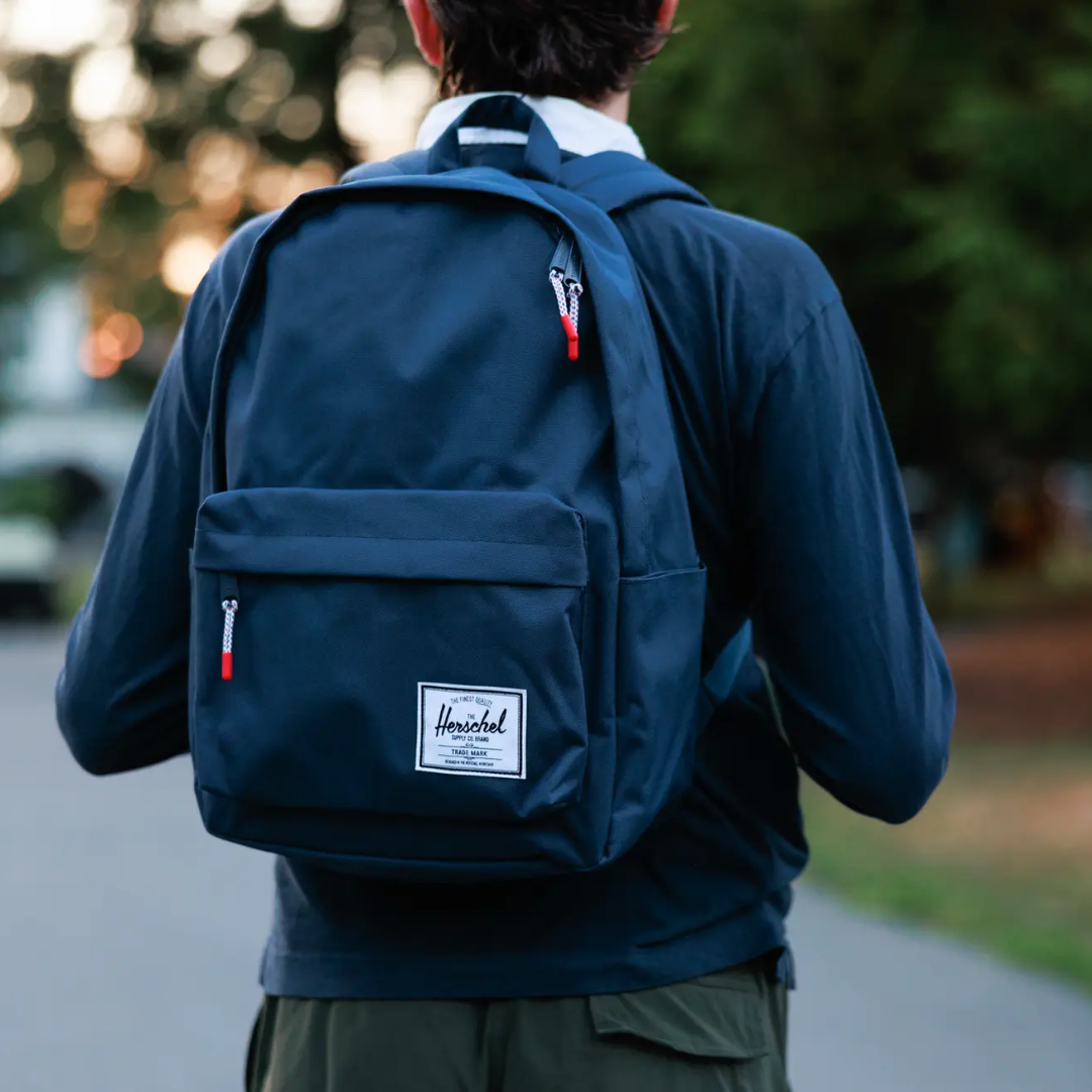 person wearing navy Herschel backpack