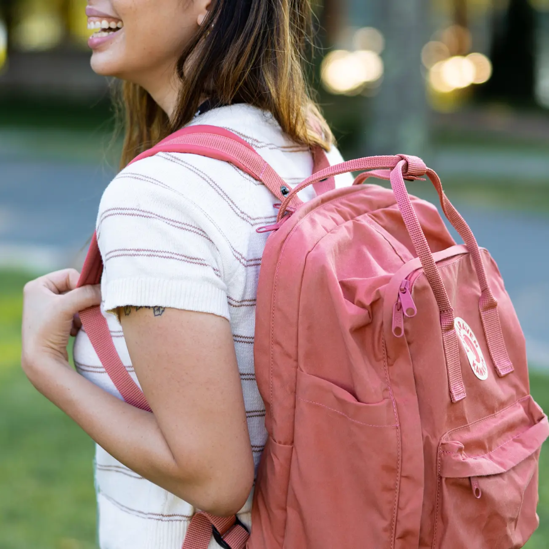 smiling girl wearing pink Fjallraven backpack