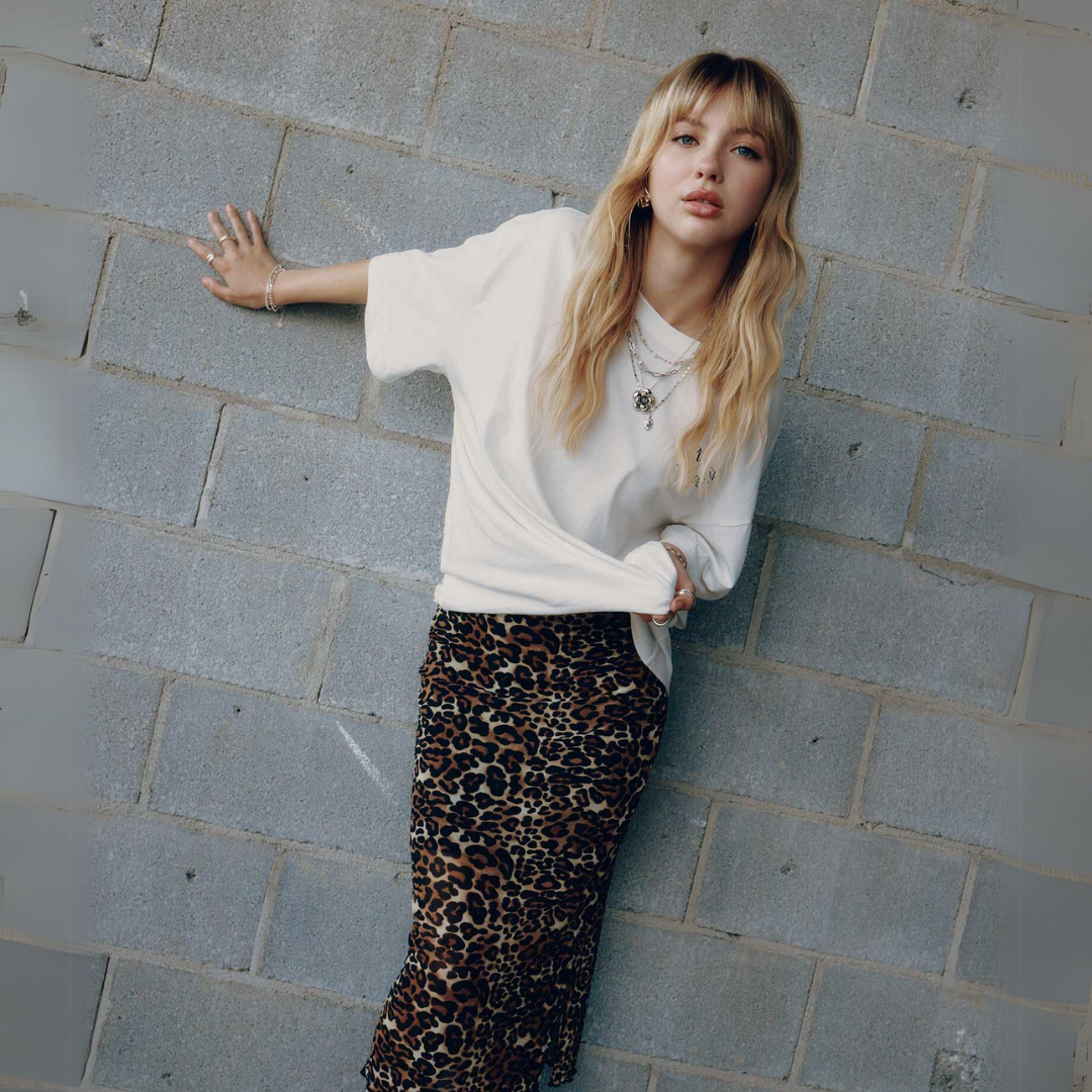 Woman in a white top and leopard print skirt