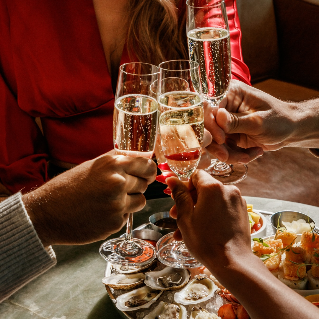 champagne glasses cheers at Earls over a plate of seafood