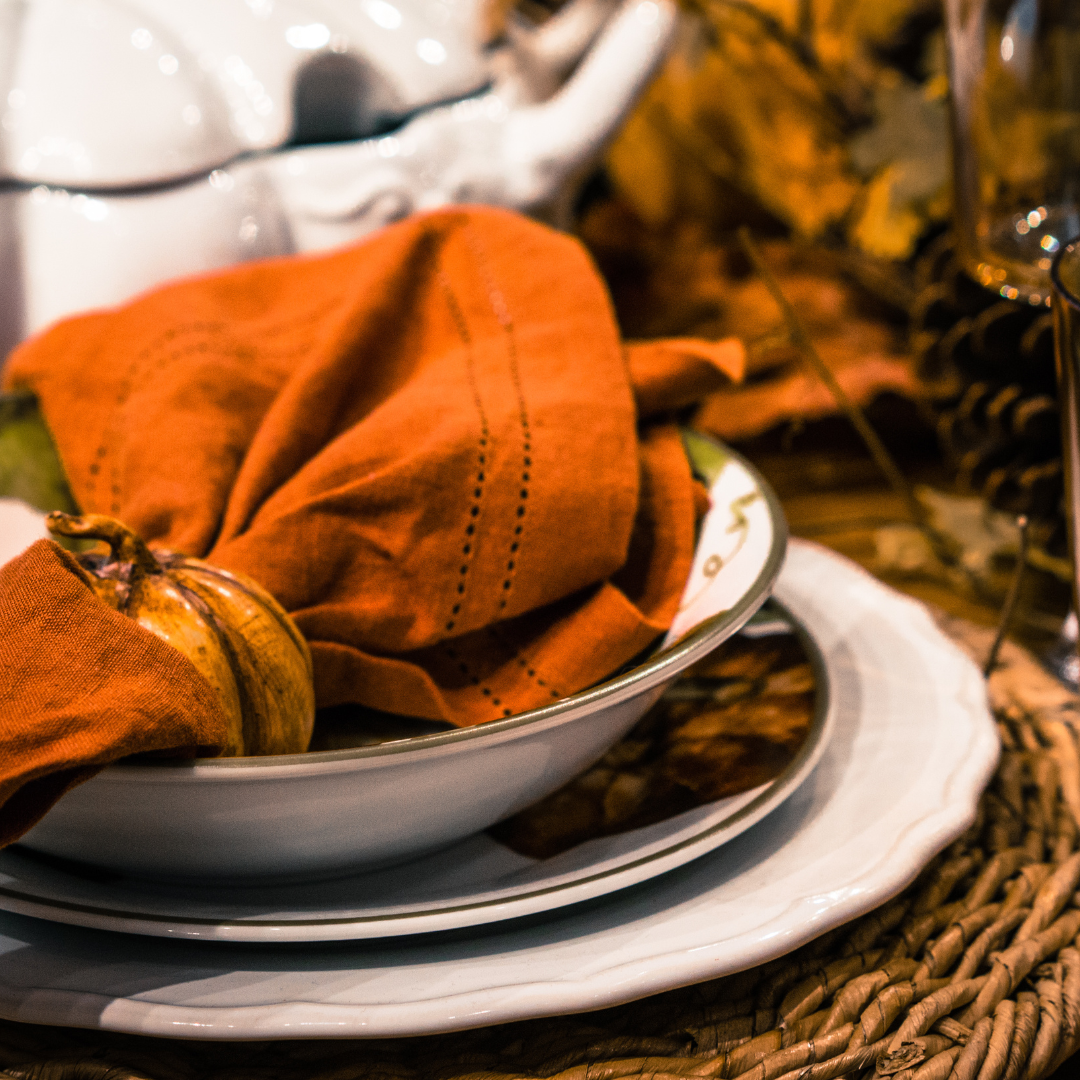 white tableware with orange cloth napkin from Stokes