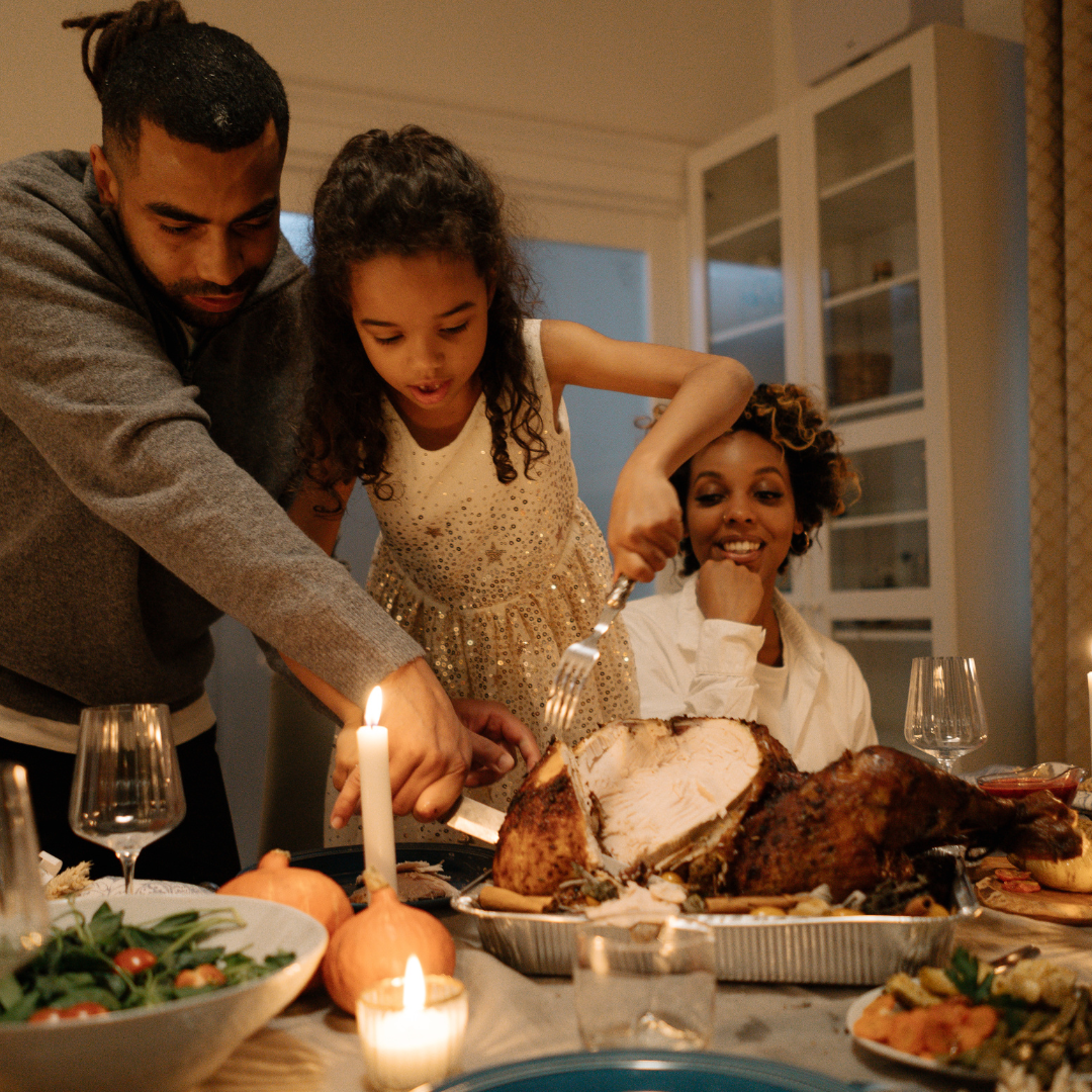 family smiling around a thanksgiving table