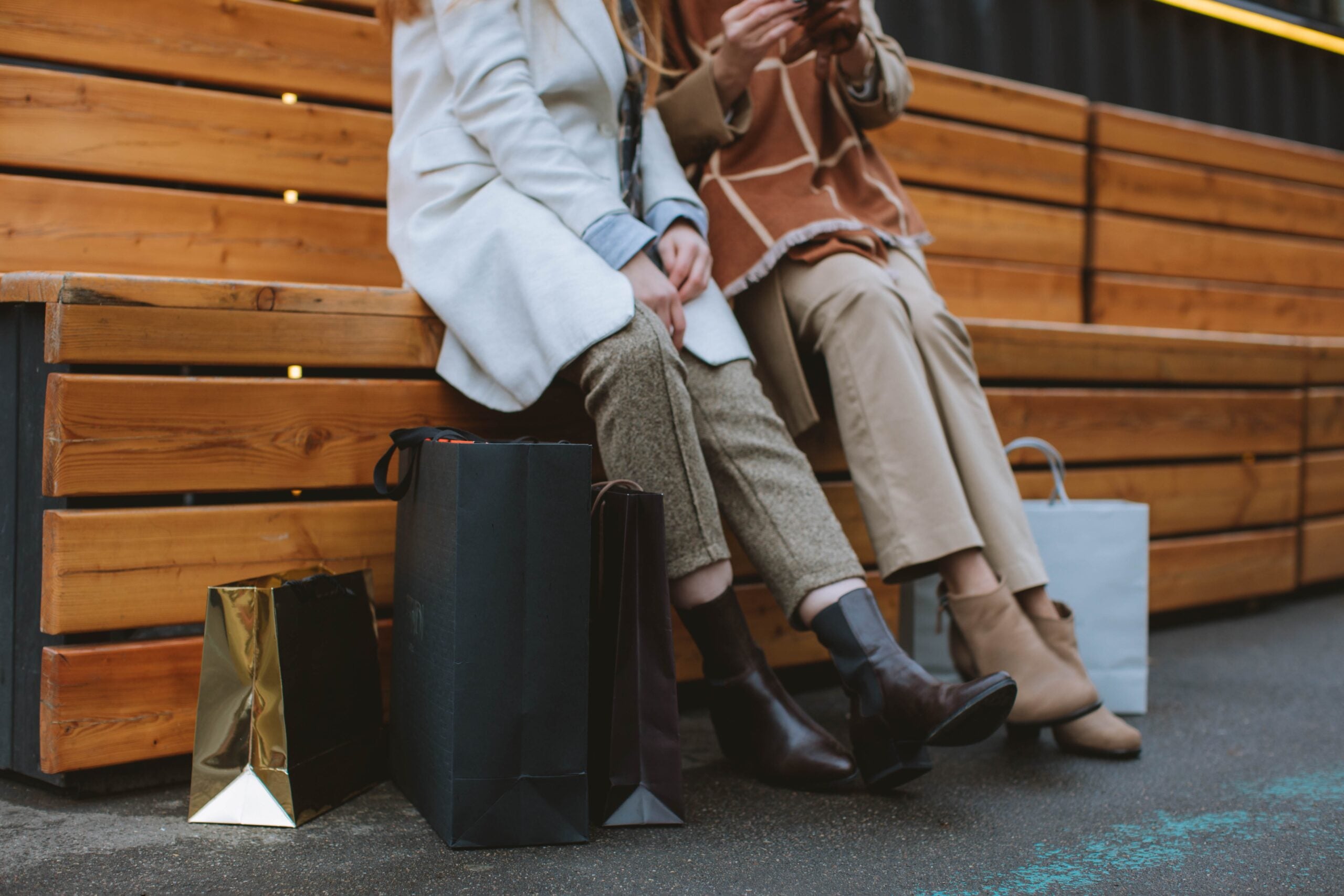 Two women sitting with shopping bags