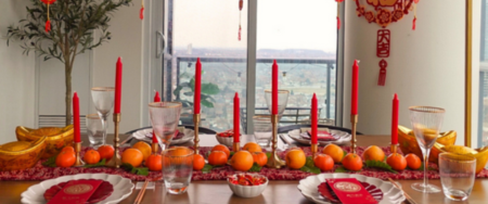 Lunar New Year table set with red, yellow and orange decor.