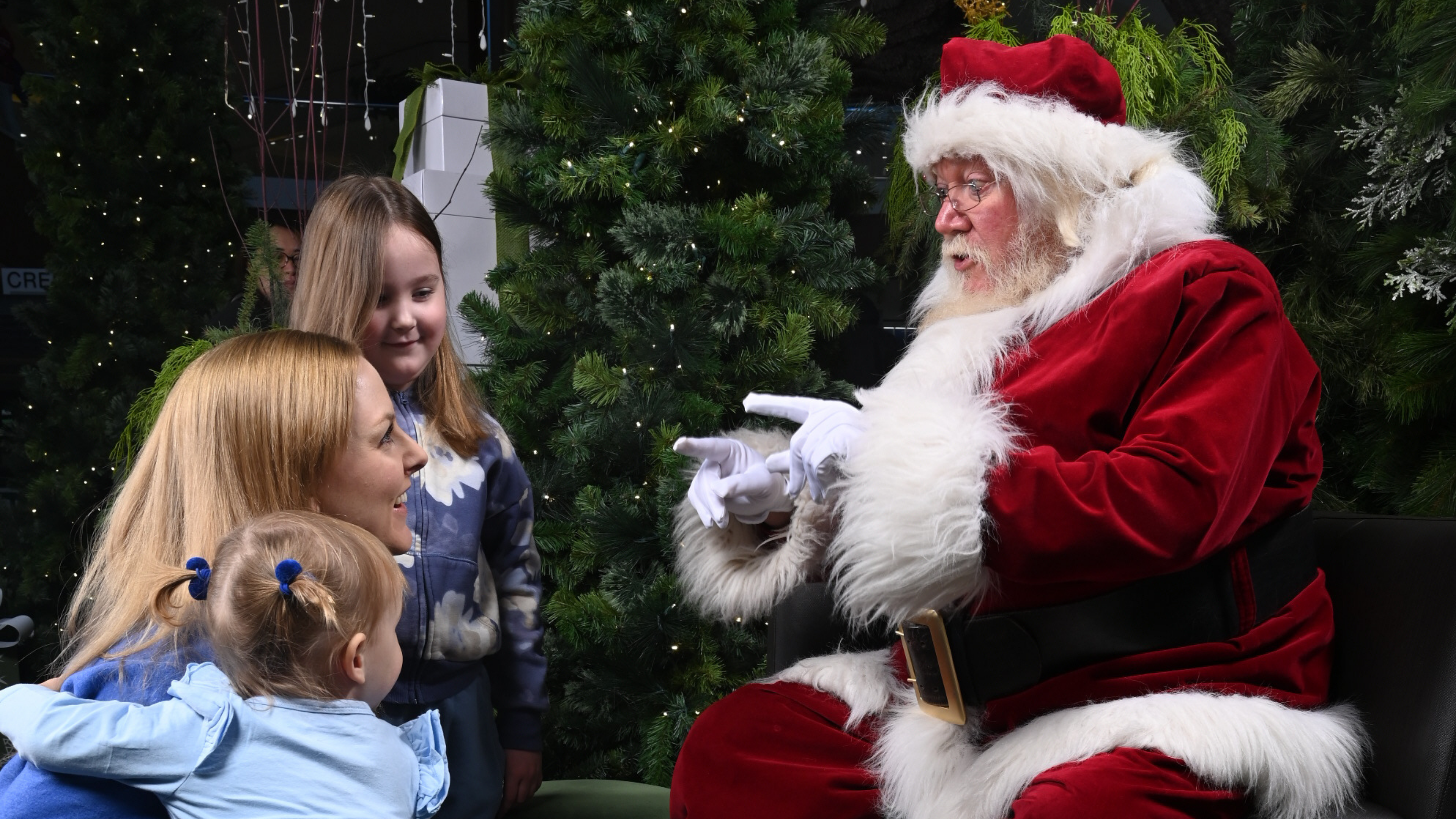 Santa Claus at the enchanted forest interacting with young children